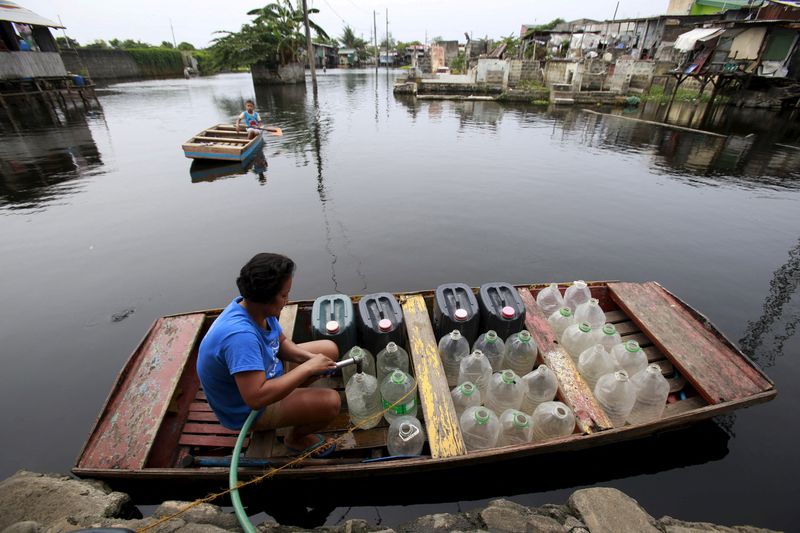&copy; Reuters. FILE PHOTO: A resident living in a flooded area refills plastic containers with drinking water on an improvised "banca" (small boat) in Artex compound, Malabon city, north of Manila, Philippines March 4, 2016. REUTERS/Romeo Ranoco/