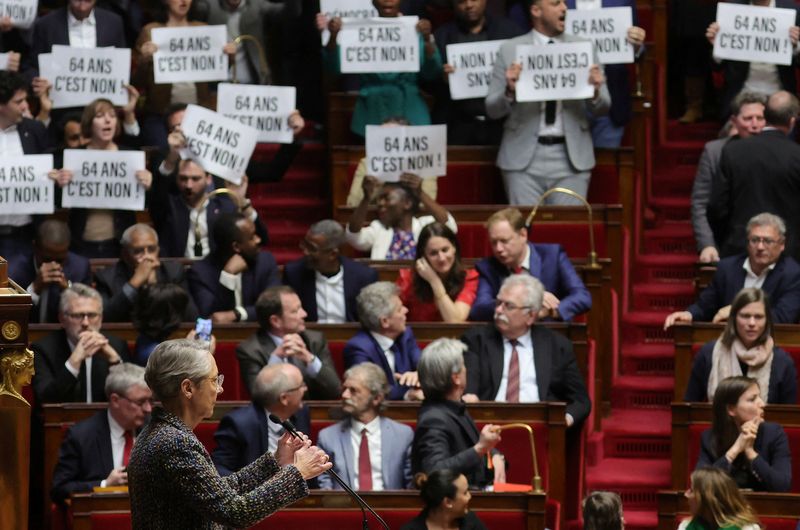 © Reuters. Des députés d'opposition brandissent des pancartes et chantent la Marseillaise alors que la Première ministre Elisabeth Borne prononce un discours sur le projet de loi de réforme des retraites à l'Assemblée nationale. /Photo prise le 16 mars 2023/REUTERS/Pascal Rossignol 