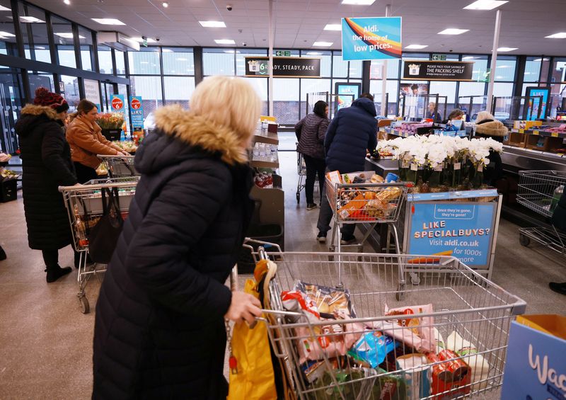 &copy; Reuters. Des personnes font leurs courses à l'intérieur d'un supermarché ALDI près d'Altrincham, en Grande-Bretagne. /Photo prise le 20 février 2023/REUTERS/Phil Noble