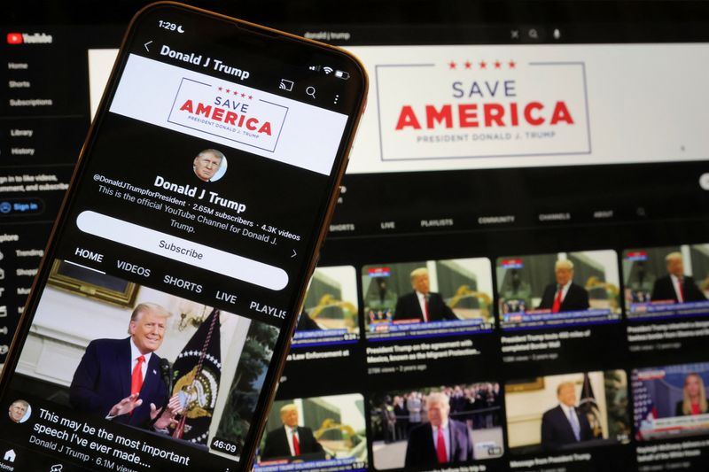 © Reuters. Former U.S. President Donald Trump's YouTube account is seen on a mobile phone and laptop computer after being restored by Google and its parent company Alphabet Inc, as Google lifted a more than two-year suspension imposed on Trump after the deadly January 6, 2021 Capitol Hill riot, in Washington, U.S. March 17, 2023.   REUTERS/Jim Bourg