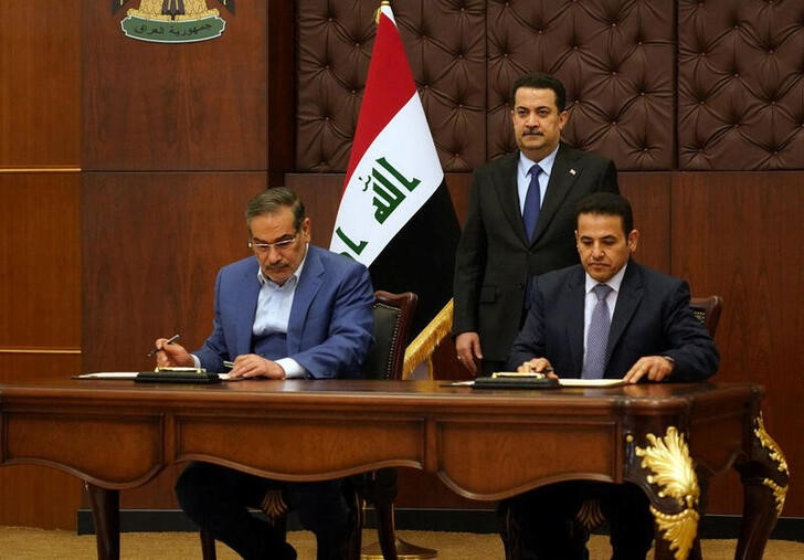 &copy; Reuters. El primer ministro iraquí, Mohammed Shia al-Sudani (detrás), mira mientras el secretario del Consejo Supremo de Seguridad Nacional iraní, Ali Shamkhani, y el asesor de Seguridad Nacional iraquí, Qasim al-Araji, firman un acuerdo de seguridad en Bagdad