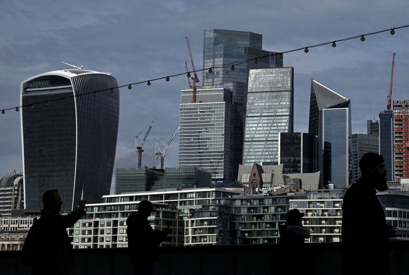 &copy; Reuters. FILE PHOTO: People walk with skyscrapers in the City of London financial district seen behind in London, Britain, March 16, 2023. REUTERS/Toby Melville/File Photo