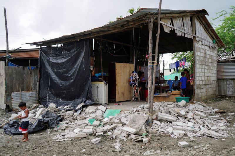 © Reuters. A boy stands next to debris following an earthquake in Isla Puna, Ecuador March 19, 2023. REUTERS/Maria Fernanda Landin