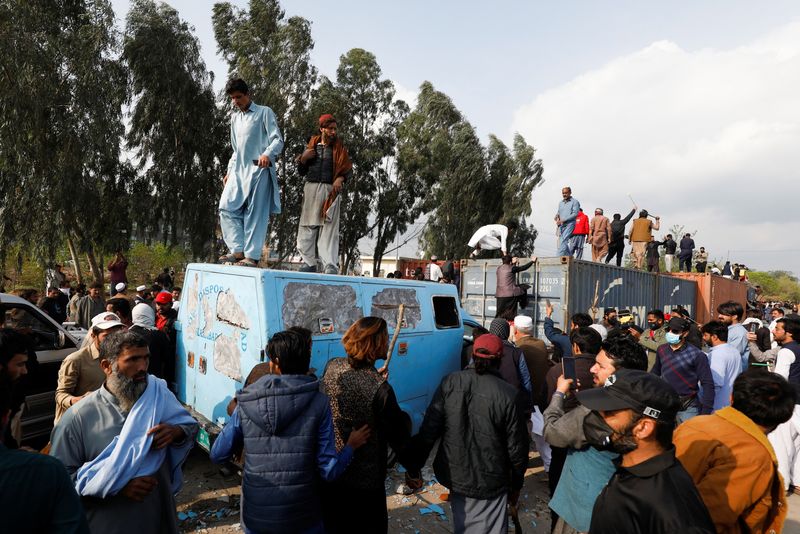 &copy; Reuters. أنصار رئيس الوزراء الباكستاني السابق عمران خان يصعدون على متن حاويات شحن متوقفة لإغلاق طريق في إسلام اباد يوم 18 مارس آذار 2023. تصوير: أختر سوم