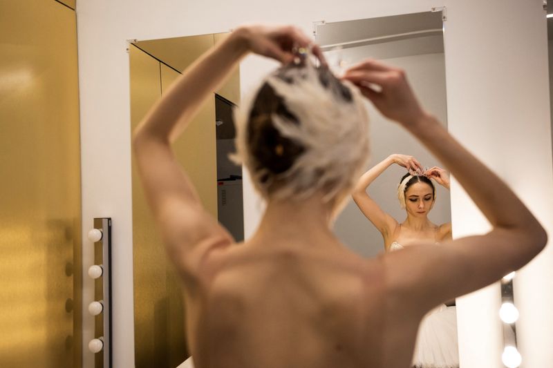 &copy; Reuters. Ganna Muromtseva, 29, a professional ballerina from Ukraine who fled her country after Russia’s invasion, tries on her headdress after a stage rehearsal for the Swan Lake ballet at the Hungarian State Opera in Budapest, Hungary, March 11, 2023. Muromtse
