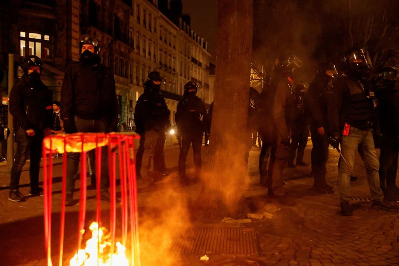 © Reuters. French police stand guard, amid clashes during a demonstration, on the day the National Assembly debates and votes on two motions of no-confidence against the French government, tabled by centrist group Liot and far-right Rassemblement National party, for its use of article 49.3, a special clause in the French Constitution, to push the pensions reform bill through the National Assembly without a vote by lawmakers, in Lille, France, March 20, 2023. REUTERS/Pascal Rossignol