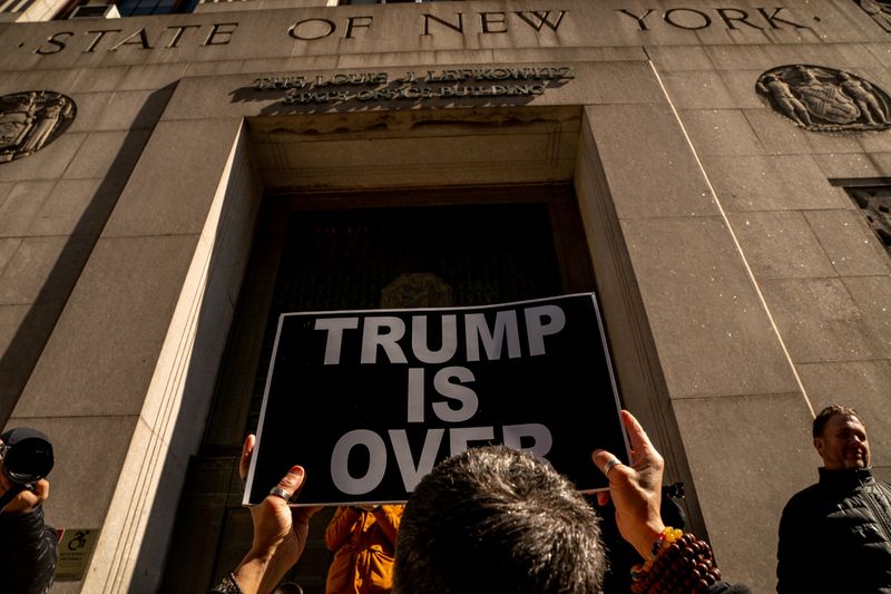 &copy; Reuters. A protestor holds a sign outside 80 Centre Street, where Manhattan District Attorney Alvin Bragg continues his investigation into former U.S. President Donald Trump, in New York City, U.S., March 20, 2023. REUTERS/David Dee Delgado