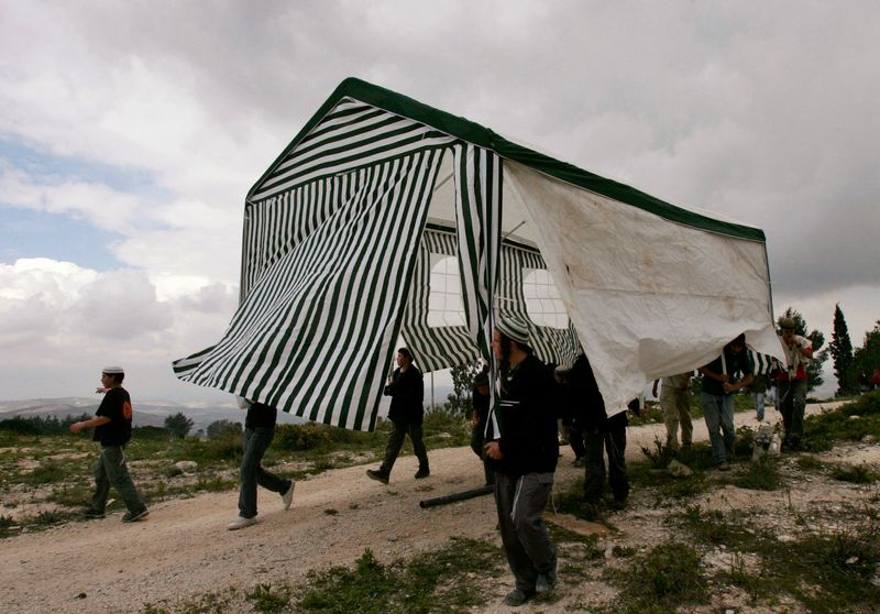 &copy; Reuters. FILE PHOTO: Israeli activists carry a tent in the abandoned Jewish settlement of Homesh, in the northern West Bank, March 27, 2007. REUTERS/Ronen Zvulun (WEST BANK)/File Photo