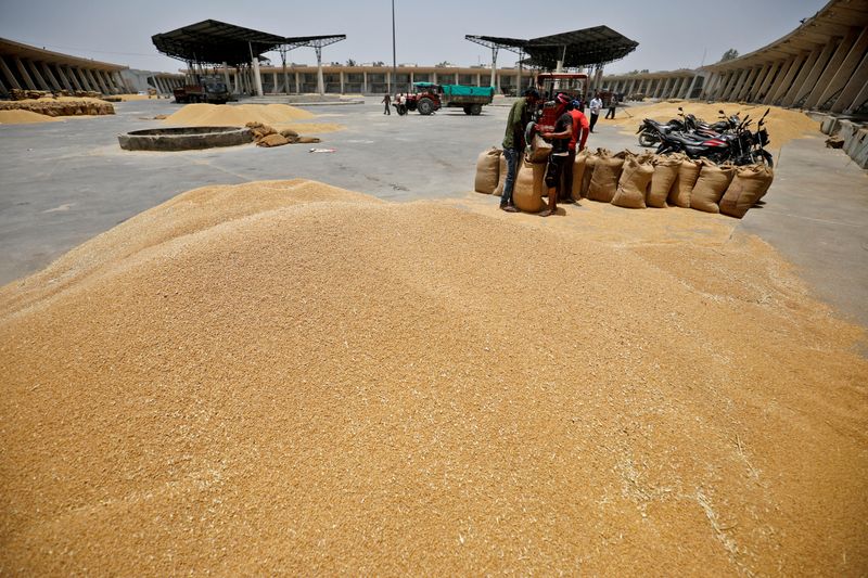 &copy; Reuters. Trabalhadores enchem sacos de trigo em mercado nos arredores de Ahmedabad, na Índia. REUTERS/Amit Dave