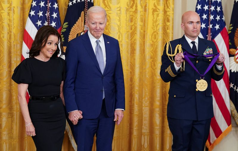 &copy; Reuters. National Medal of Arts recipient actor Julia Louis-Dreyfus holds hands with U.S. President Joe Biden as she waits to be presented her medal during a ceremony in the East Room at the White House in Washington, U.S., March 21, 2023. REUTERS/Kevin Lamarque