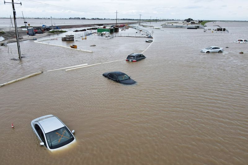 © Reuters. Cars sit abandoned on roads as floodwaters from the Tule River inundate the area after days of heavy rain in Corcoran, California, U.S., March 21, 2023.  REUTERS/David Swanson