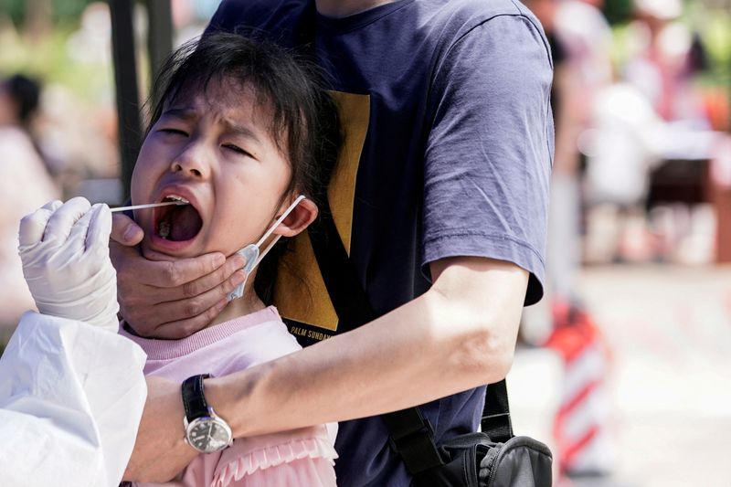 &copy; Reuters. FOTO DE ARCHIVO: Una niña reacciona mientras se somete a una prueba de ácido nucleico en Wuhan, la ciudad china más afectada por el brote de la enfermedad por coronavirus (COVID-19), provincia de Hubei, China. 16 de mayo, 2020. REUTERS/Aly Song/Archivo