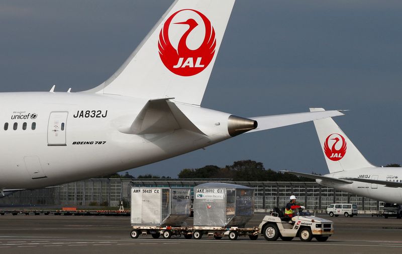 &copy; Reuters. FILE PHOTO: A airport worker drives a luggage transport vehicle past one of the company's Boeing Co's 787 Dreamliner plane (L) and a Beoing 767 at Narita international airport in Narita, east of Tokyo, November 11, 2013. JREUTERS/Toru Hanai/File Photo