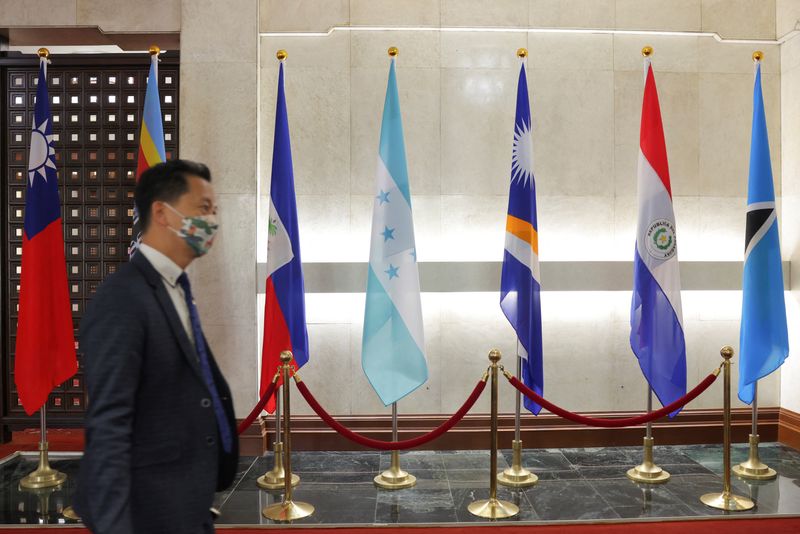 © Reuters. A man walks in front of flags of Honduras, Taiwan, and other countries, displayed at the Ministry of Foreign Affairs building, in Taipei, Taiwan March 23, 2023. REUTERS/Annabelle Chih