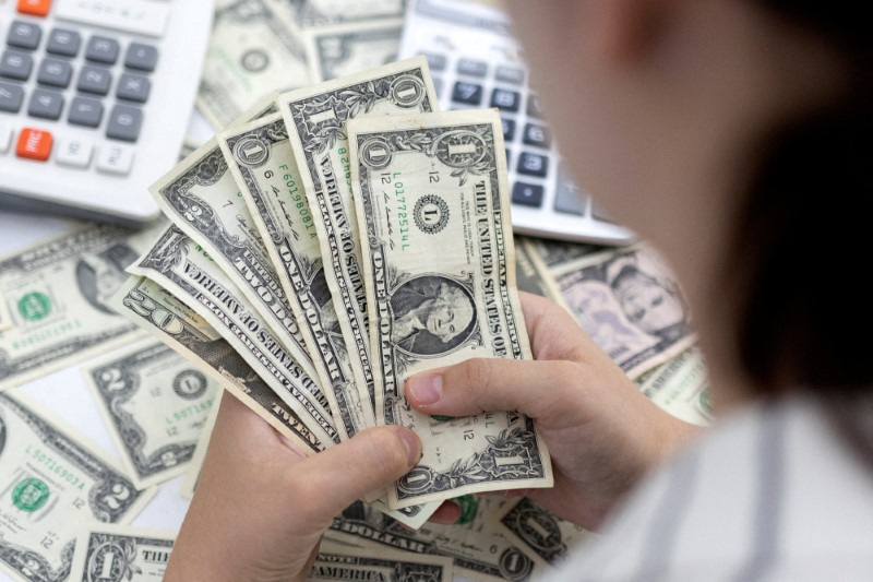 &copy; Reuters. Una donna conta banconote da un dollaro statunitensi. REUTERS/Dado Ruvic