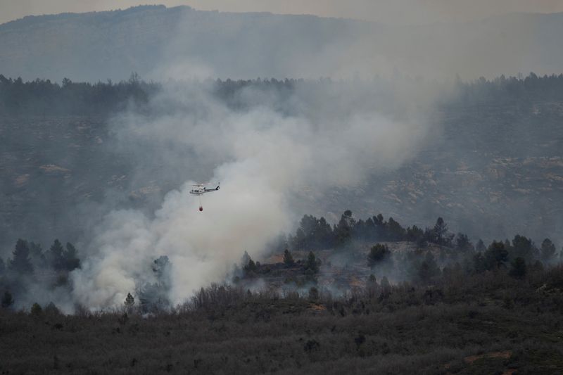 &copy; Reuters. طائرة هليكوبتر تسقط المياه في محاولة لإطفاء حريق غابات في سان أوجستين في إسبانيا يوم الجمعة. تصوير: لورينا سوبينا - رويترز.