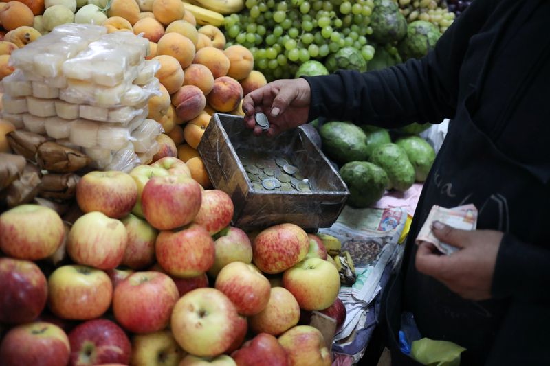 &copy; Reuters. FILE PHOTO: A seller charges money at a stand at Surco market in Lima, Peru August 31, 2018.  REUTERS/Mariana Bazo