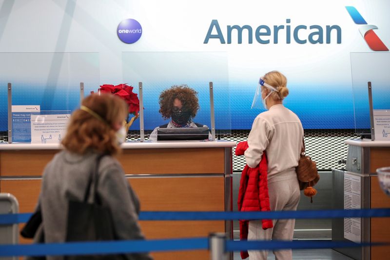 © Reuters. FILE PHOTO: American Airlines agent helps a customer to check in for her flight at O'Hare International Airport ahead of the Thanksgiving holiday during the coronavirus disease (COVID-19) pandemic, in Chicago, Illinois, U.S. November 25, 2020. REUTERS/Kamil Krzaczynski