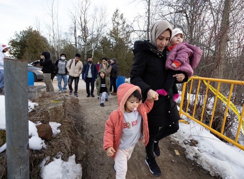&copy; Reuters. Asylum seekers that stated they were from Afghanistan cross into Canada at Roxham Road, an unofficial crossing point from New York State to Quebec in Champlain, New York, U.S. March 24, 2023.  REUTERS/Christinne Muschi