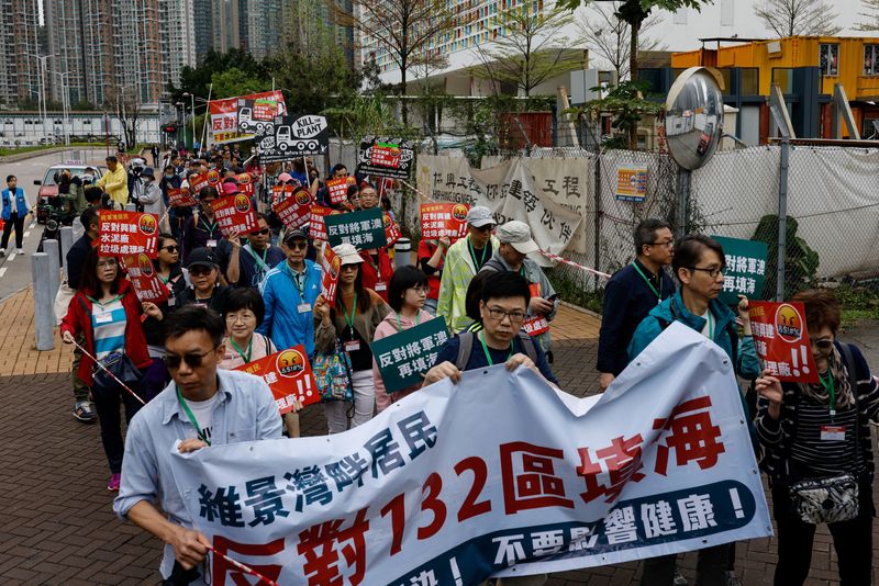 © Reuters. Protesters are required to wear numbered lanyards around their necks as they protest against a land reclamation and waste transfer station project during one of the first demonstrations to be formally approved since the enactment of a sweeping national security law, in Hong Kong, China March 26, 2023. REUTERS/Tyrone Siu