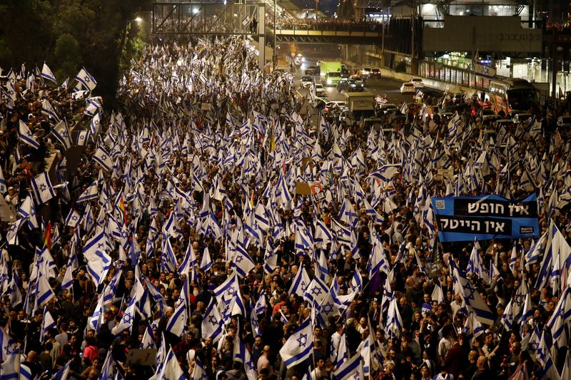 © Reuters. People attend a demonstration after Israeli Prime Minister Benjamin Netanyahu dismissed the defense minister and his nationalist coalition government presses on with its judicial overhaul, in Tel Aviv, Israel, March 26, 2023. REUTERS/Nir Elias