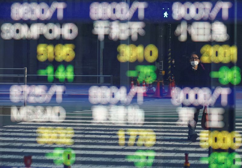 © Reuters. FILE PHOTO: A man is reflected on an electronic board displaying various companies' stock prices outside a brokerage in Tokyo, Japan, February 22, 2022. REUTERS/Kim Kyung-Hoon/File Photo sizes=