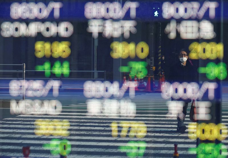 &copy; Reuters. FILE PHOTO: A man is reflected on an electronic board displaying various companies' stock prices outside a brokerage in Tokyo, Japan, February 22, 2022. REUTERS/Kim Kyung-Hoon/File Photo