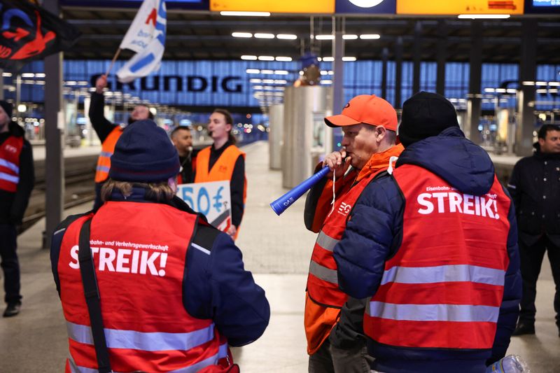 © Reuters. Workers protest at Munich's main train station during a nationwide strike called by the German trade union Verdi over a wage dispute in Munich, Germany, March 27, 2023. REUTERS/Lukas Barth