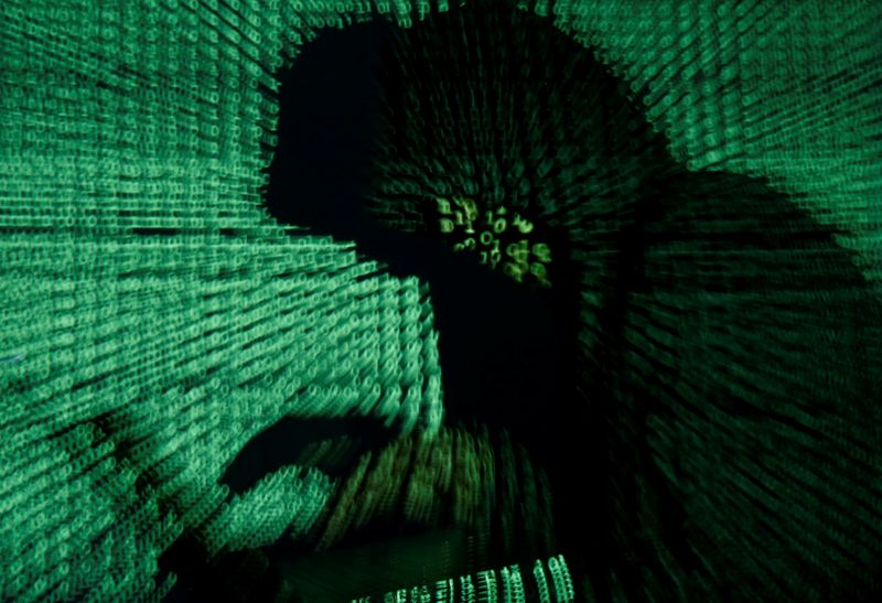 &copy; Reuters. A man holds a laptop computer as cyber code is projected on him in this illustration picture taken on May 13, 2017. REUTERS/Kacper Pempel/Illustration