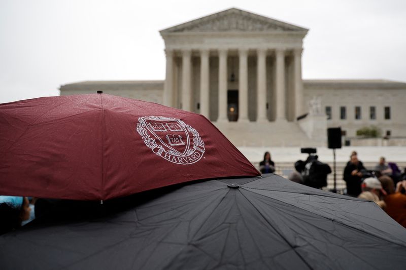 &copy; Reuters. A person holds an umbrella with a Harvard logo print as demonstrators gather in support of affirmative action, as the U.S. Supreme Court is set to consider whether colleges may continue to use race as a factor in student admissions in two cases, at the U.