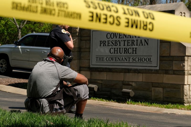 &copy; Reuters. Mario Dennis, l'un des cuisiniers de l'école Covenant, assis près d'un policier après une fusillade dans l'établissement scolaire. /Photo prise le 27 mars 2023 à Nashville, Tennessee, aux États-Unis/REUTERS/Kevin Wurm