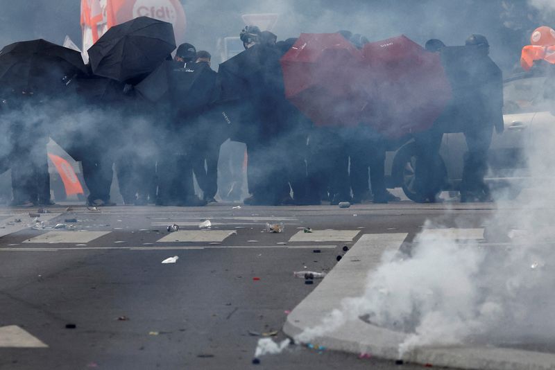 © Reuters. Manifestantes se protegen con paraguas en medio de gases lacrimógenos durante los enfrentamientos en una manifestación como parte del décimo día de huelgas y protestas contra la reforma de las pensiones del Gobierno francés en Nantes, Francia. 28 de marzo de 2023.   REUTERS/Stephane Mahe   