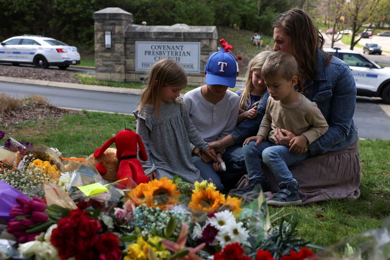 © Reuters. Emily Ryan and her children pray at a memorial at the school entrance after a deadly shooting at The Covenant School in Nashville, Tennessee, U.S., March 28, 2023. REUTERS/Austin Anthony