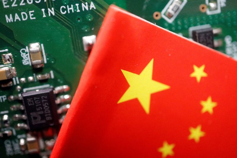&copy; Reuters. FILE PHOTO: A Chinese flag is displayed next to a "Made in China" sign seen on a printed circuit board with semiconductor chips, in this illustration picture taken February 17, 2023. REUTERS/Florence Lo/Illustration