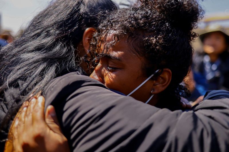 &copy; Reuters. Migrant Elerith Medina is hugged by an activist during a protest outside the National Institute of Migration building after a fire broke out late on Monday at a migrant detention center, in Ciudad Juarez, Mexico, March 28, 2023. REUTERS/Jose Luis Gonzalez