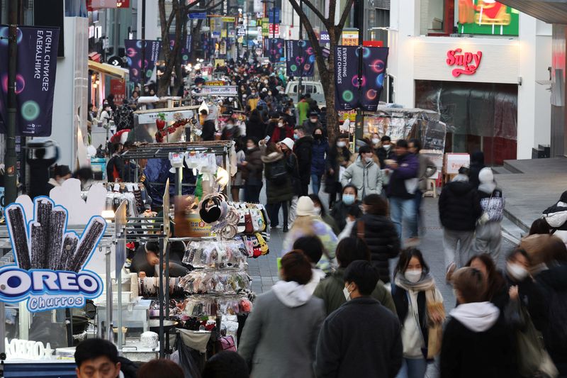&copy; Reuters. FILE PHOTO: Street vendors (L) wait for customers at Myeongdong shopping district in Seoul, South Korea, January 9, 2023.    REUTERS/Kim Hong-Ji