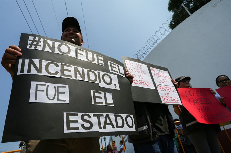 &copy; Reuters. Ativistas seguram cartazes -- um deles diz "Não foi o incêndio. Foi o Estado" -- em à morte de migrantes em incêndio em um centro de detenção na cidade fronteiriça de Ciudad Juarez
29/03/2023 
REUTERS/Gabriela Sanabria 