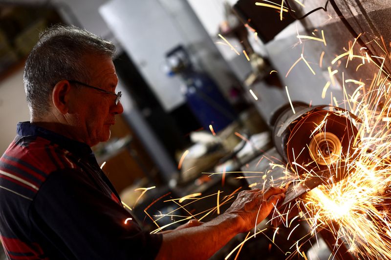 &copy; Reuters. Jorge Pedro Armoa, 67, works with metal in one of his three jobs to beat Argentina's over 100% inflation rate, in 9 de Abril, in the outskirts of Buenos Aires, Argentina March 21, 2023. REUTERS/Tomas Cuesta