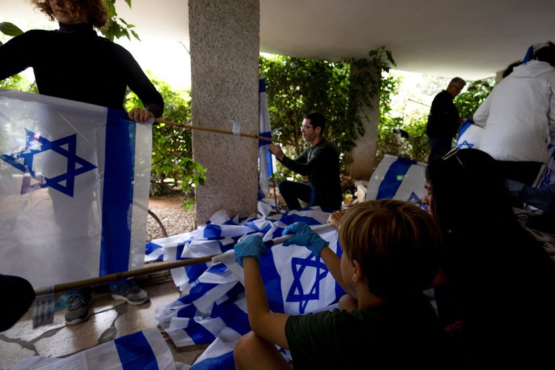 &copy; Reuters. متطوعون يجمعون الأعلام الإسرائيلية استعدادًا لمزيد من الاحتجاجات الجماهيرية في تل أبيب يوم الخميس. تصوير: رونن زفولون رويترز. 