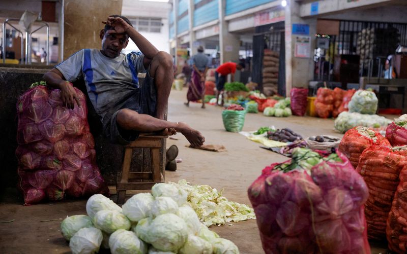 © Reuters. FILE PHOTO: A vendor waits for customers at his vegetable stall at a main market in Colombo, Sri Lanka February 10, 2023. REUTERS/Dinuka Liyanawatte