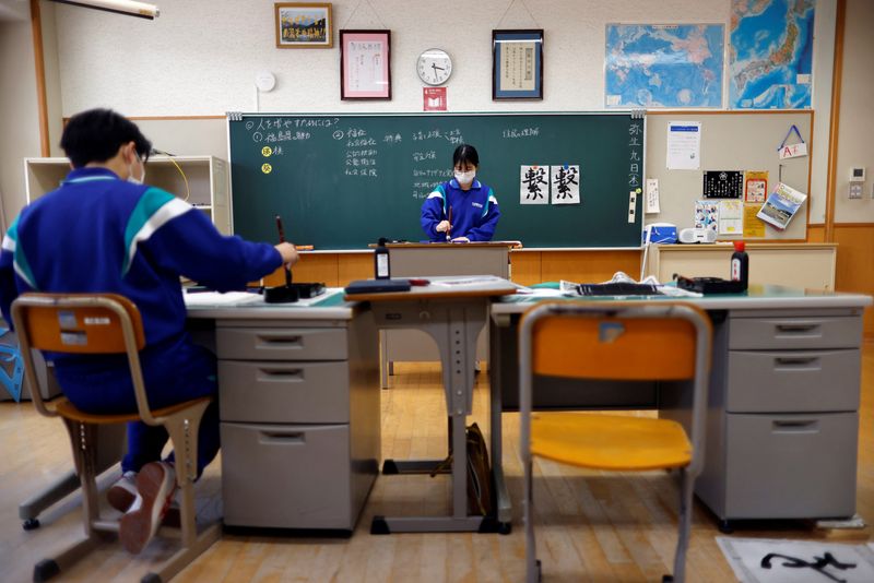 &copy; Reuters. Eita Sato, 15, and Aoi Hoshi, 15, who are the only two students at Yumoto Junior High School, attend a Japanese traditional calligraphy class to write a message that will be engraved into the school's closing memorial stone, a few days before their gradua