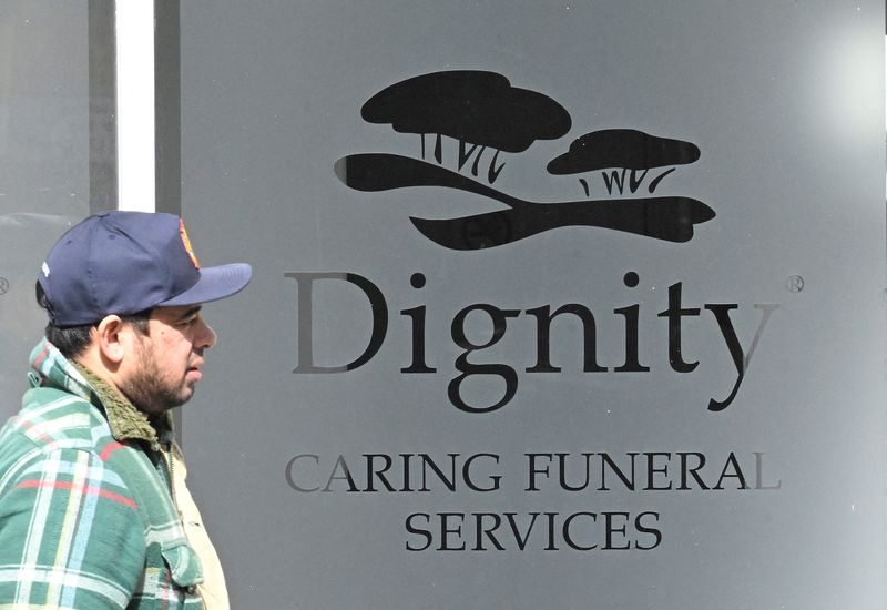 &copy; Reuters. FILE PHOTO: A man walks past a Dignity funeral directors building in London, Britain, March 25, 2023. REUTERS/Toby Melville