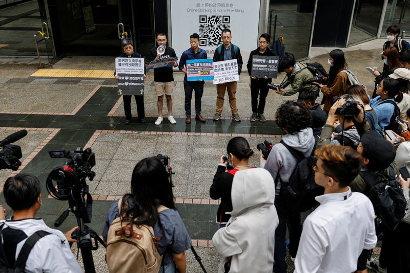 &copy; Reuters. Henry Tse and applicants hold placards to protest for a gender change on their identity cards to be processed after winning a landmark court case in February, in Hong Kong, China March 31, 2023. REUTERS/Tyrone Siu