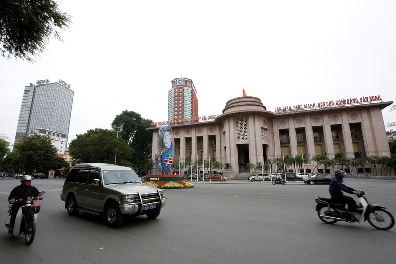 &copy; Reuters. FILE PHOTO: People go past the State Bank building, near the offices of Vietcombank and the Bank for Investment and Development of Vietnam, in central Hanoi, Vietnam November 23, 2017. REUTERS/Kham