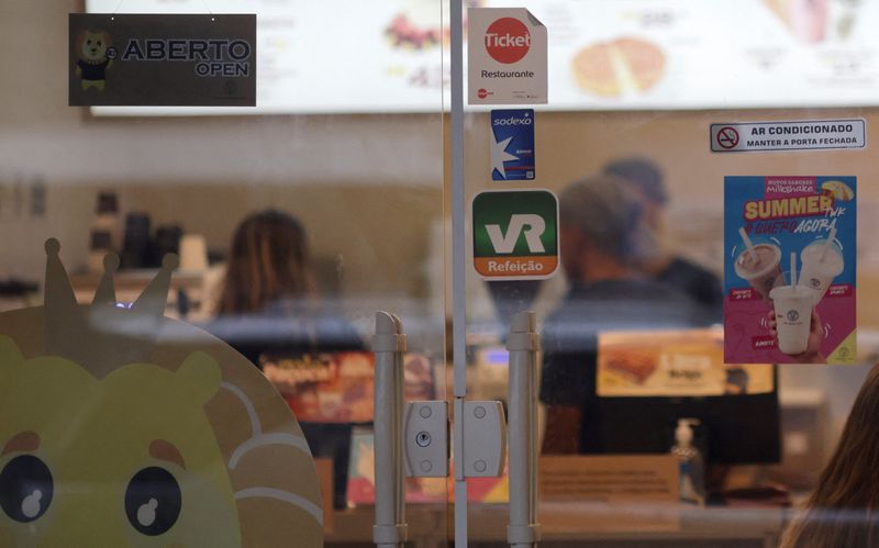 &copy; Reuters. FILE PHOTO: Stickers of meal vouchers companies are pictured on the entrance door of a coffee shop, in Rio de Janeiro, Brazil March 28, 2023. REUTERS/Ricardo Moraes