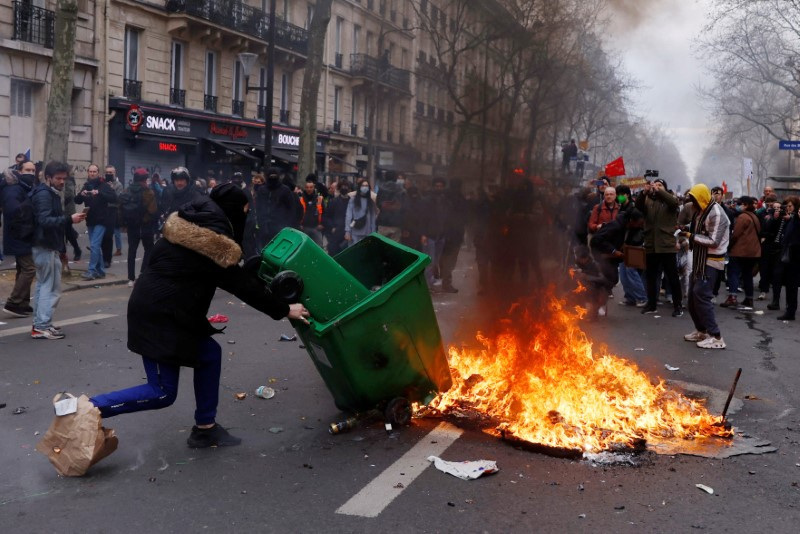 © Reuters. A protester sets a garbage bin on fire during clashes at a demonstration as part of the tenth day of nationwide strikes and protests against the French government's pension reform, in Paris, France, March 28, 2023. REUTERS/Gonzalo Fuentes