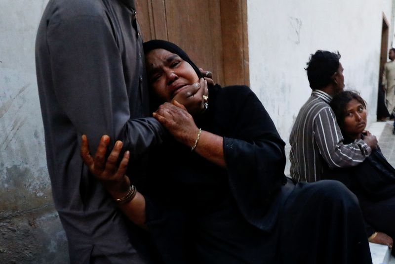 © Reuters. أقارب قتلى تدافع المساعدات الغذائية في جنوب باكستان ينتحبون على ذويهم في مستشفى كراتشي يوم الجمعة. تصوير: أختار سومرو - رويترز.