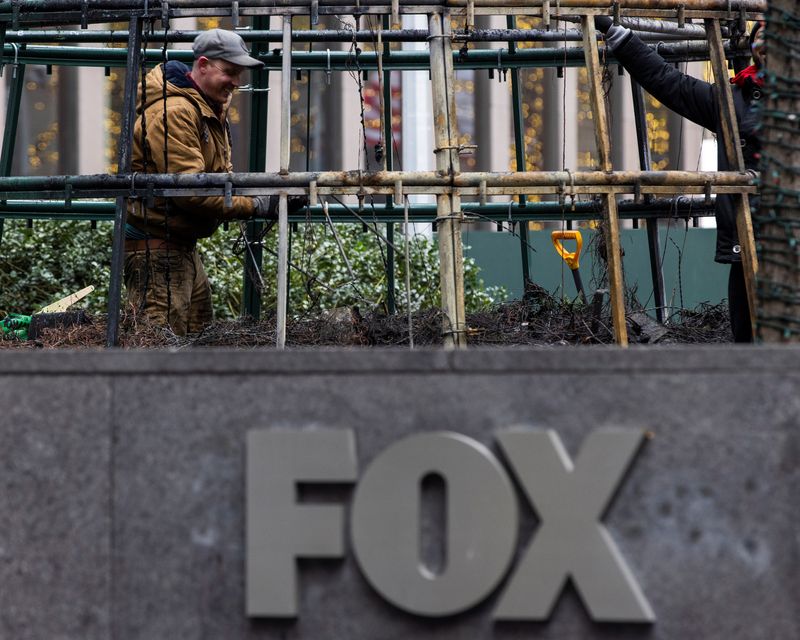 &copy; Reuters. FILE PHOTO: Workers clean up the burnt remains of a Christmas tree outside the News Corp. and Fox News building in New York City, New York, U.S. December 8, 2021. REUTERS/Eduardo Munoz