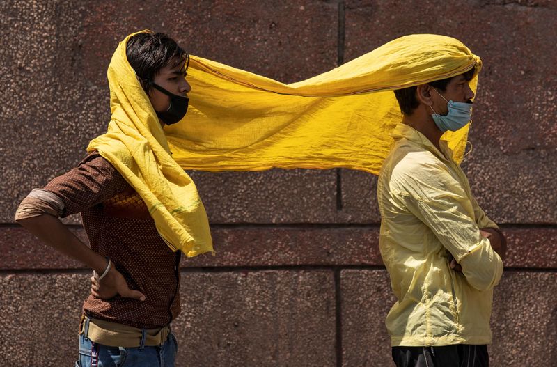 &copy; Reuters. عاملان هنديان يغطيان أنفسهما بوشاح يحميهما من الحرارة في نيودلهي بالهند. صورة من أرشيف رويترز 