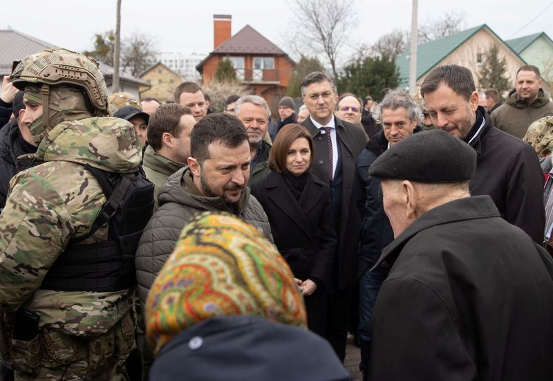 © Reuters. Slovenia's Prime Minister Robert Golob, Ukraine's President Volodymyr Zelenskiy, Moldovan President Maia Sandu, Croatian Prime Minister Andrej Plenkovic and Slovakian Prime Minister Eduard Heger speak with local residents as they visit the town of Bucha marking the first anniversary of its liberation, amid Russia's attack on Ukraine, outside of Kyiv, Ukraine March 31, 2023. Ukrainian Presidential Press Service/Handout via REUTERS  